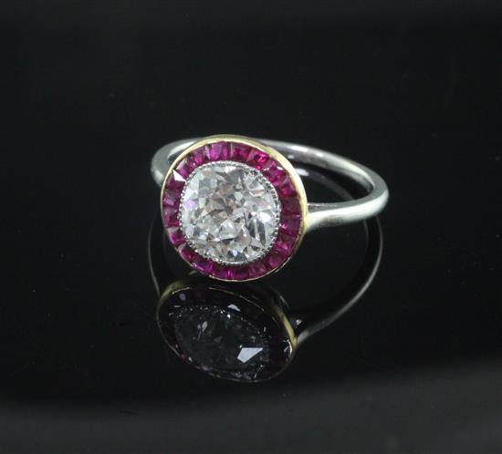 An early 20th century platinum and single stone diamond ring with ruby set yellow gold border, size K/L.